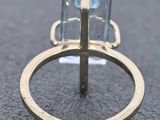 a close up of a gold ring with a blue topaz stone