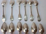 six spoons and six spoons sitting on a table