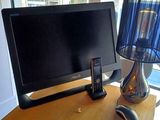 a desk with a computer monitor and a phone on it