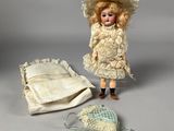 a doll that is standing next to a bag