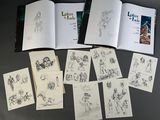 a lot of drawings on the table and a book
