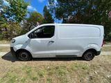 a white van parked in a field with trees in the background