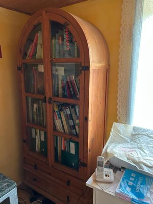 a bookcase with many books in it in the corner of a room