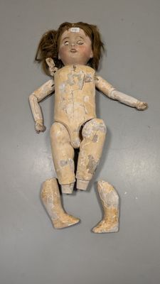 une image représentant une petite poupée se trouve sur une surface grise
