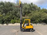 un chariot élévateur jaune garé sur un parking
