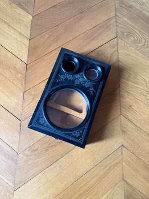 a small black box on the floor with a magnifying glass