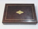 a small wooden box with a gold leaf on it