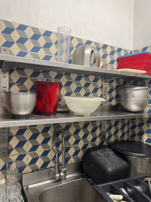 many pots and pans on the shelves in the kitchen