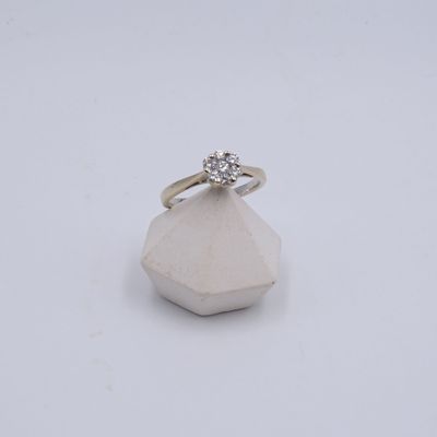 une photo d'une bague en diamant posée sur un rocher