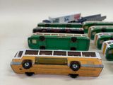 several toy buses are lined up in a row on a white surface