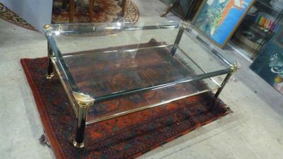 une table basse en verre posée sur un tapis au sol