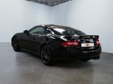 the rear end of a black sports car parked in a garage