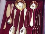 a lot of silver spoons and spoons in a box