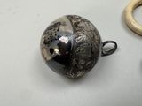 a silver ball and a pair of scissors on a table