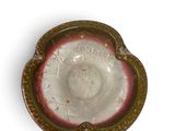 an antique glass ashtray with a woman ' s face in the center