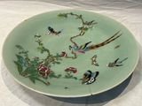 une assiette décorée d'oiseaux et de fleurs, posée sur une table