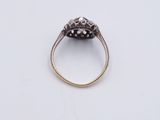 a close up of a gold and diamond ring on a white surface