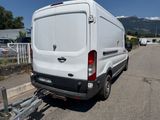 a white van parked in a parking lot with mountains in the background