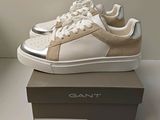 the white and gold sneakers are sitting on top of a box