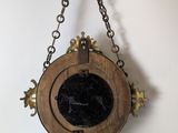 a clock hanging from a chain on the wall