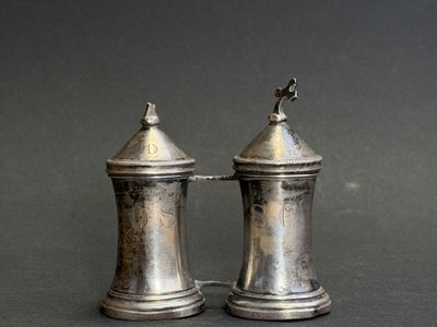 two silver salt and pepper shakers sitting on a table