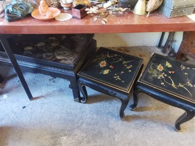 une table avec deux tabourets et une table sur laquelle est posé un vase