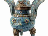 a blue and gold teapot with a bird on top