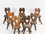 six wooden children ' s chairs are arranged in a row on a white surface