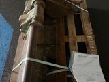 a wooden crate with a large metal object on top of it