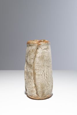 un vase blanc surmonté d'un couvercle marron, posé sur une table
