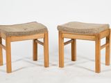 pair of wooden stools with upholstered seats on a white background