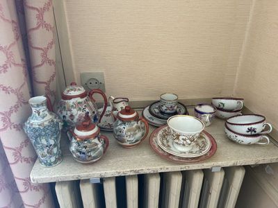 une table sur laquelle sont disposées de nombreuses tasses à thé et soucoupes de différents types
