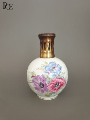 a white vase with flowers painted on it on a table