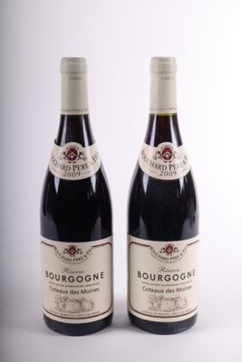 two bottles of red wine sitting next to each other on a white surface