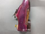 purple shoes with brown soles on a gray surface