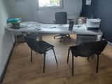 a desk with two chairs and a laptop on it