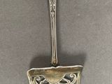 a silver spoon with a handle on a table