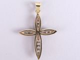 a close up of a gold cross with pearls on a white background