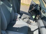 the interior of a car with the door open and the driver ' s seat down