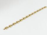 gros plan d'un bracelet en chaîne en or sur fond blanc