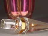 a bottle of perfume sitting on a table next to a glass vase