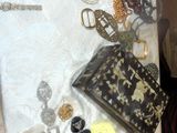 une table sur laquelle sont posés de nombreux bijoux et un sac à main