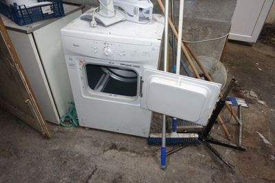 une machine à laver et un sèche-linge blancs, posés dans une pièce sale