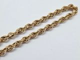 a close up of a gold chain on a white surface