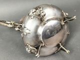 a silver plate with a spoon and spoon rest on it