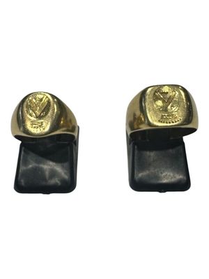 pair of gold plated men ' s and women ' s rings on black leather
