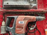 une boîte rouge contenant une perceuse et un marteau