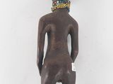 a wooden figure of a woman with a beaded head