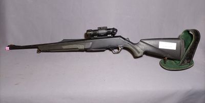the rifle is laying on the table next to the bag