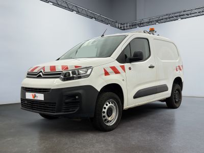 une camionnette Citroën rayée de rouge et de blanc, garée dans un garage